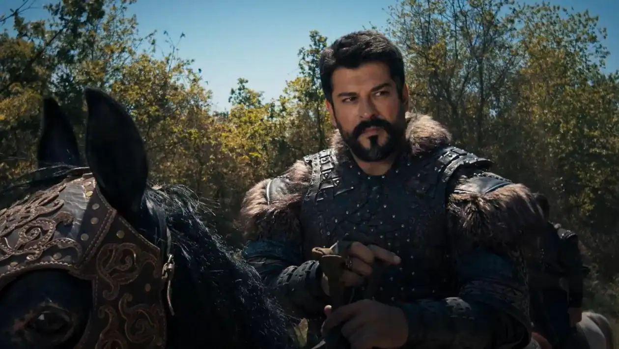 a man in armor holding a sword and standing next to a horse